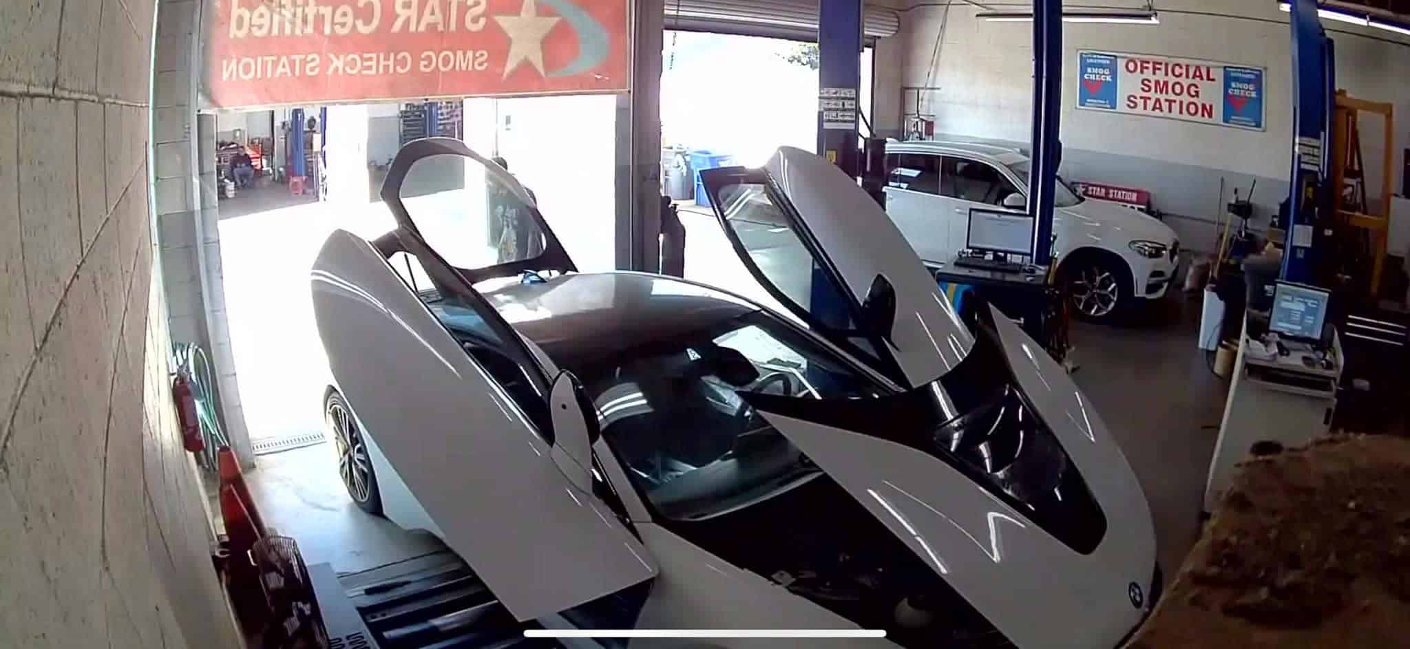 High-tech vehicle smog check station with advanced testing equipment and a sleek car on the lift.