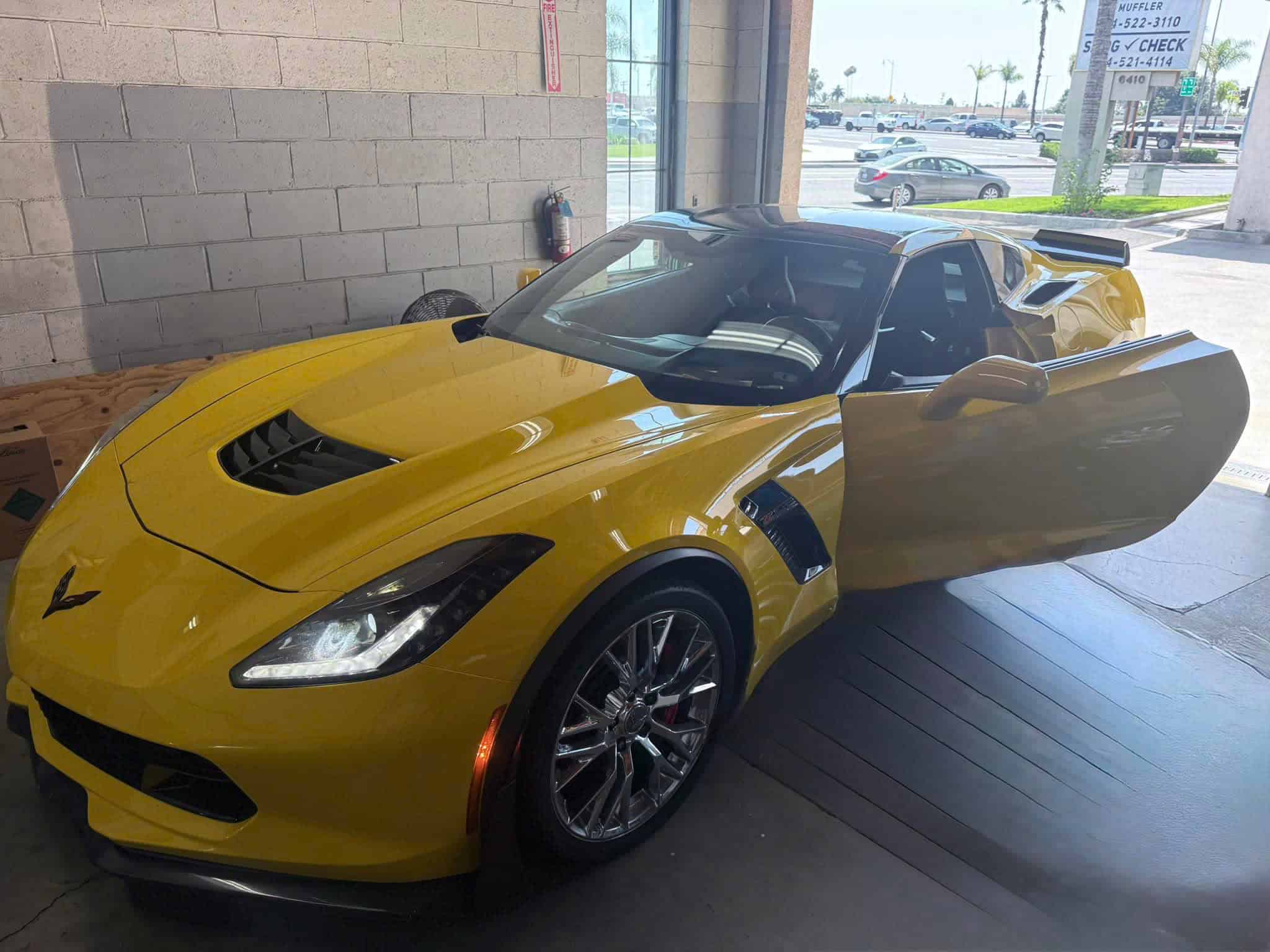Yellow sports car inside Vu & Vu Smog Check Test Only Center for vehicle inspection.